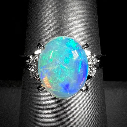 A diamond-accented platinum filigree ring mounted with a green and blue crystal opal.