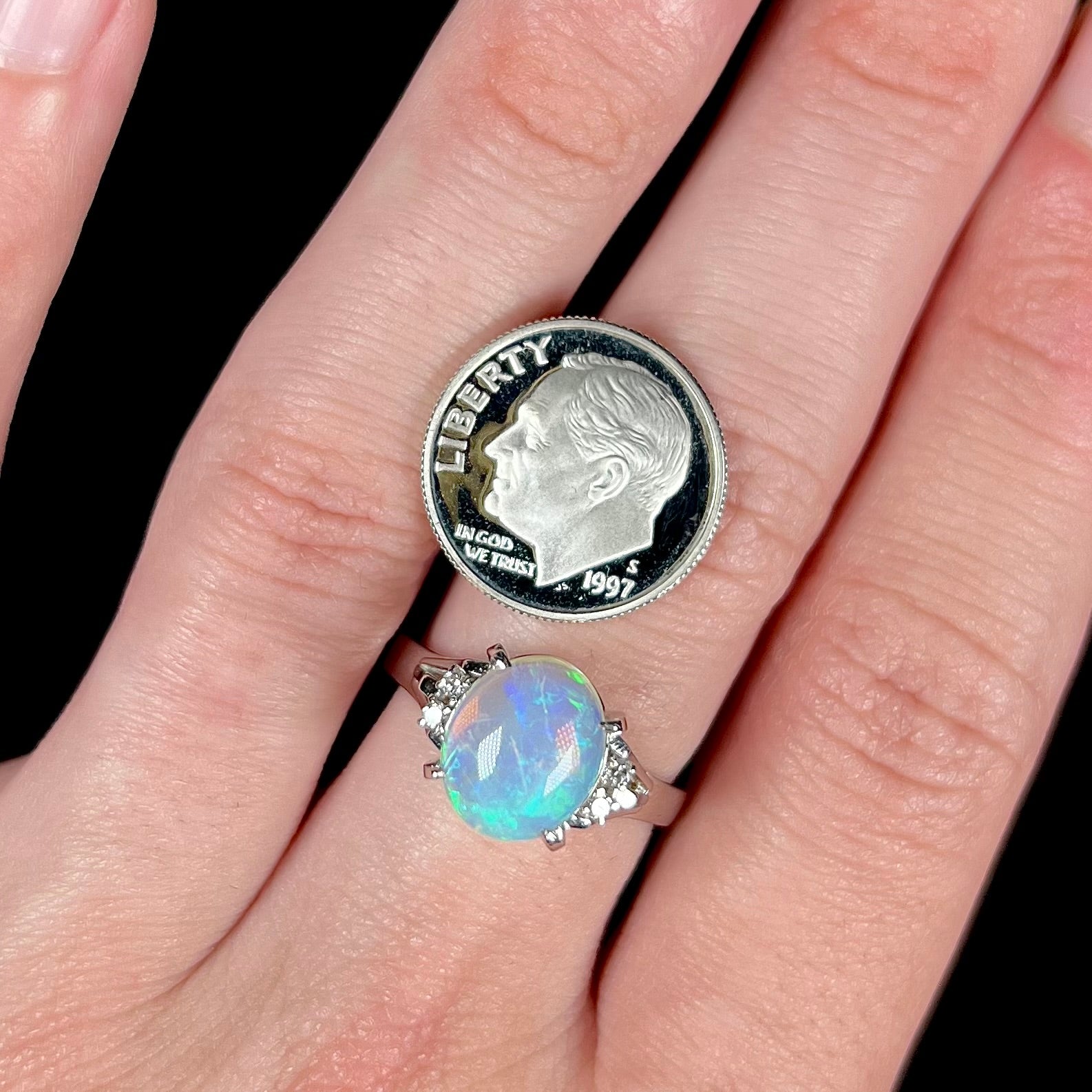 A platinum filigree ring set with a Lightning Ridge crystal opal and diamond accents.