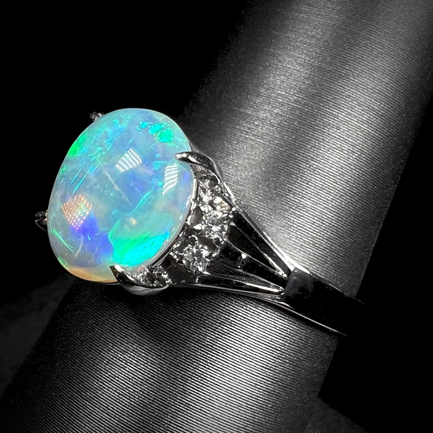 A platinum filigree ring set with a Lightning Ridge crystal opal and diamond accents.