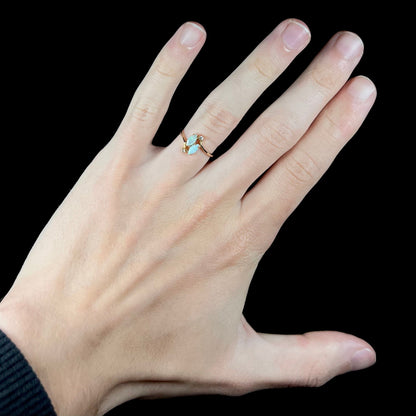 A ladies' gold ring mounted with two marquise cut opals and two diamond accents.
