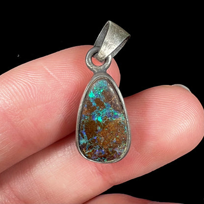 A handmade, satin finish sterling silver pendant set with a drop shaped boulder opal stone.