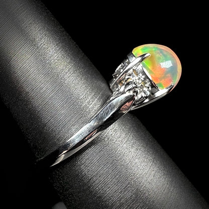 Side view of a delicate platinum fire opal ring, showcasing its slender band, vintage-inspired design, and a 2.28ct Mexican fire opal center stone.