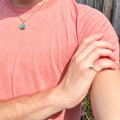 A ladies' gold ring mounted with two marquise cut opals and two diamond accents.