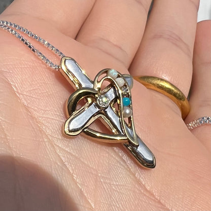 A two-tone sterling silver mother's cross necklace set with diamond, opal, turquoise, and pearl, shown in sunlight.