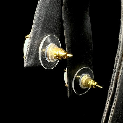 Plastic disc backs of opal stud earrings on display