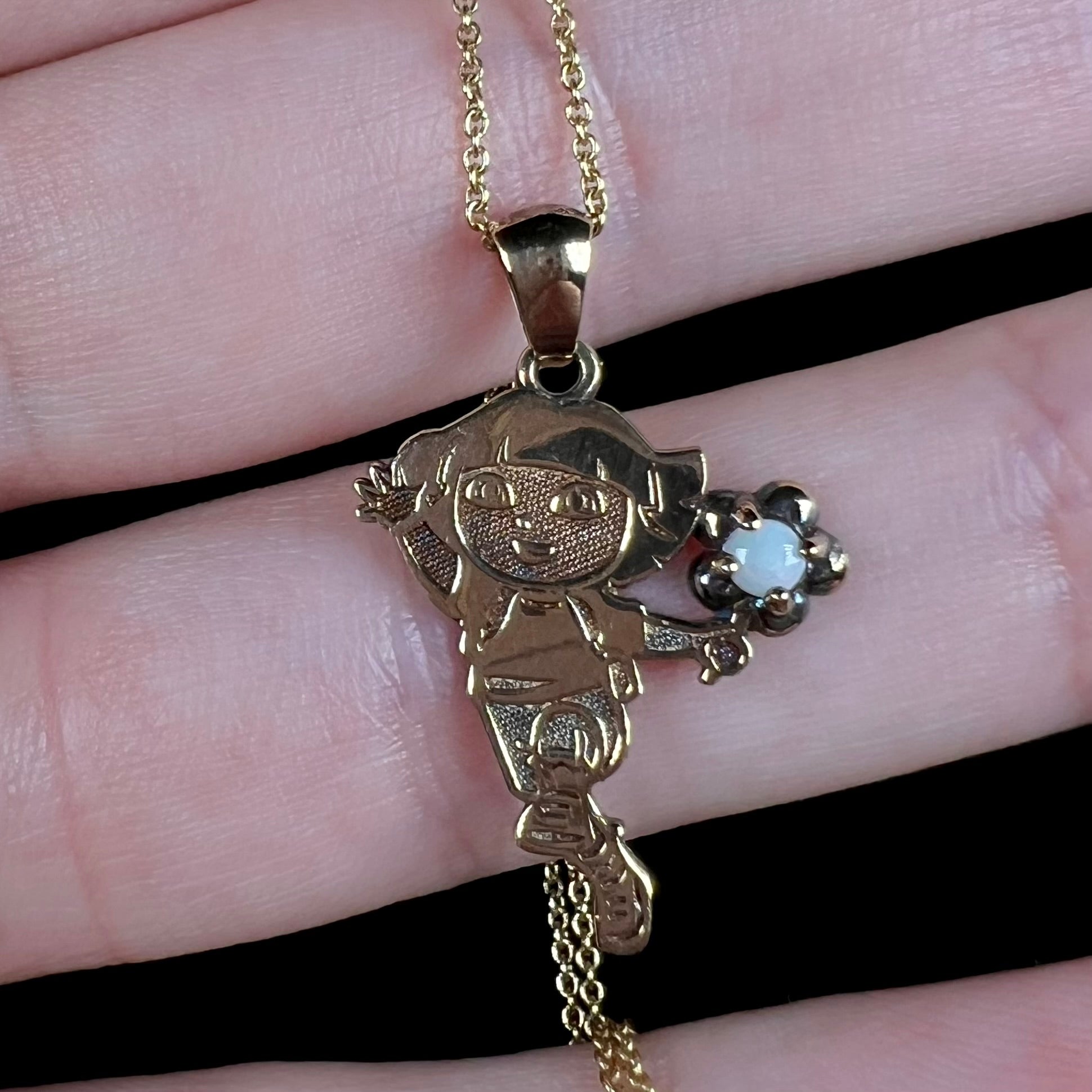 Close-up of a gold-tone Dora the Explorer Fine Jewelry Collection necklace set with a round Australian opal.