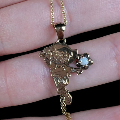 Close-up of a gold-tone Dora the Explorer Fine Jewelry Collection necklace set with a round Australian opal.