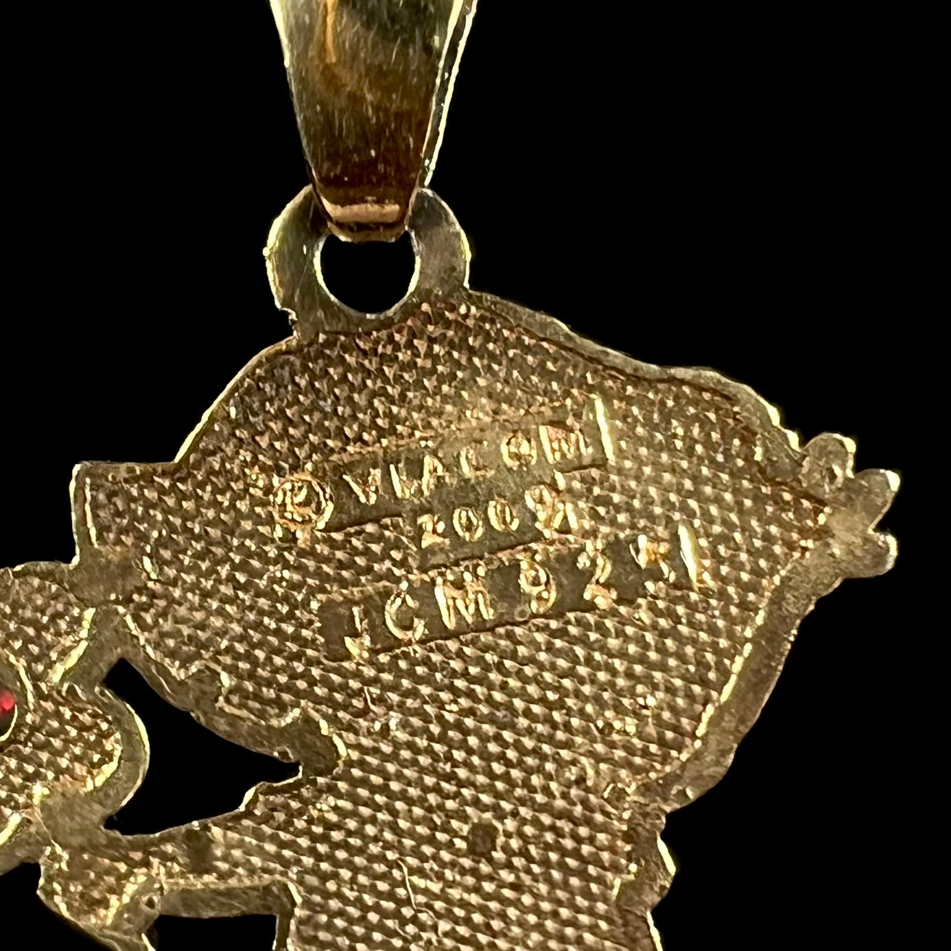 Close-up of stamps on back of gold-tone Dora the Explorer pendant that read "VIACOM 2009 JCM 925".