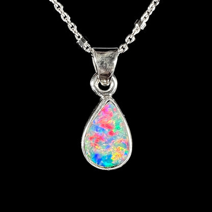 A pear shaped black opal necklace set in sterling silver.  The opal vividly flashes every color of the rainbow.