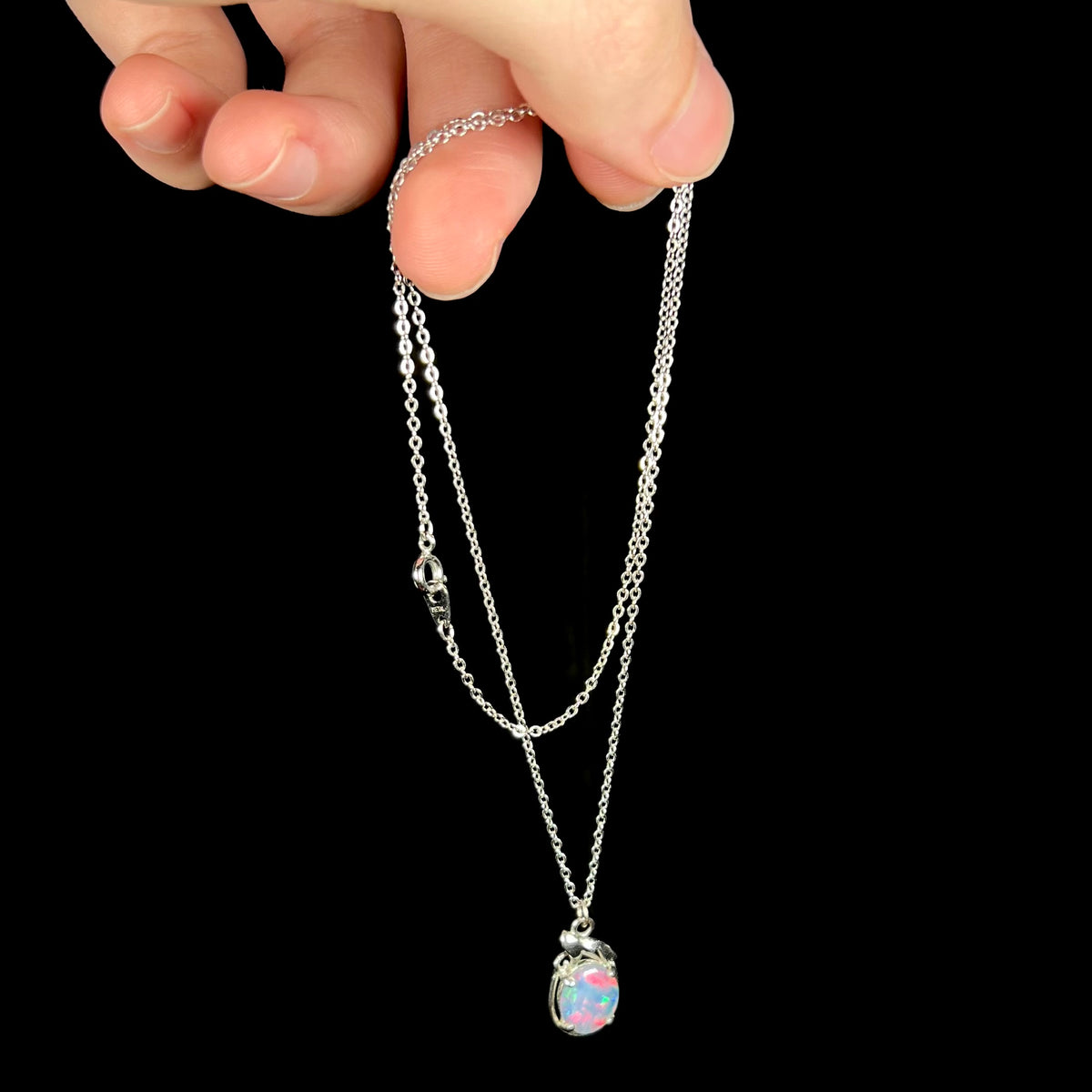Hand dangling estate base metal triplet opal necklace from chain