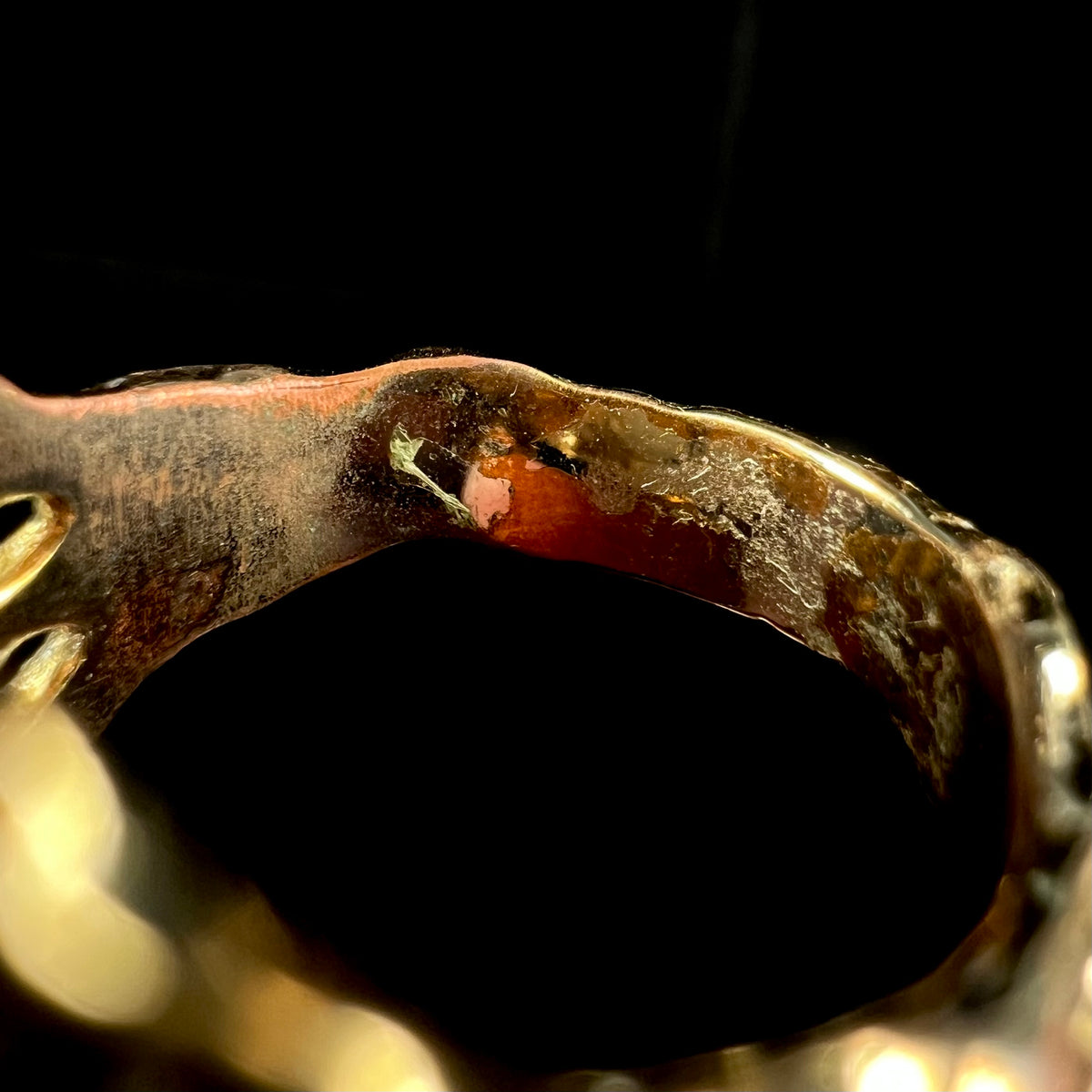 Macro view of inside of estate gold-plated costume ring's shank.  Wear is visible where the gold plating has worn through.
