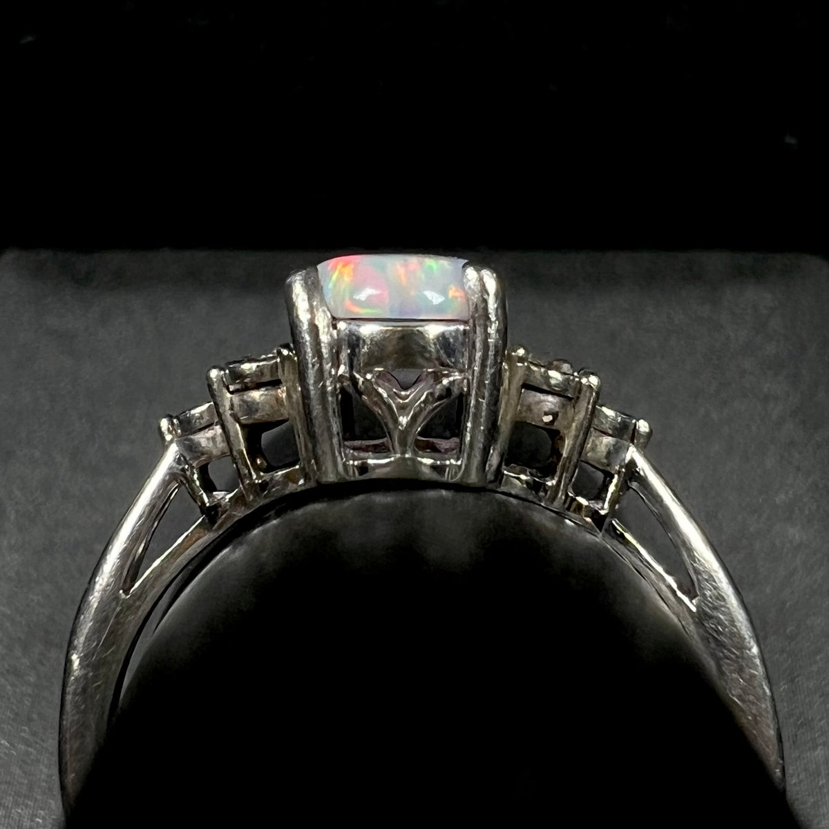 Gallery profile view of estate sterling silver opal and diamond ring.  The ring appears to be slightly misshapen, light wear visible along its shank.