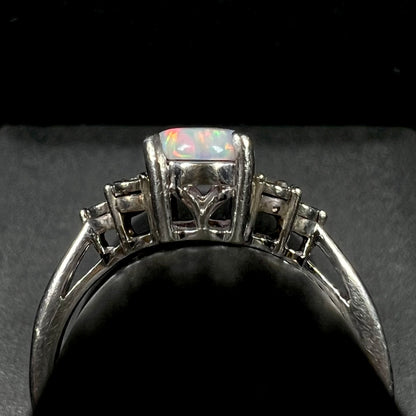 Gallery profile view of estate sterling silver opal and diamond ring.  The ring appears to be slightly misshapen, light wear visible along its shank.