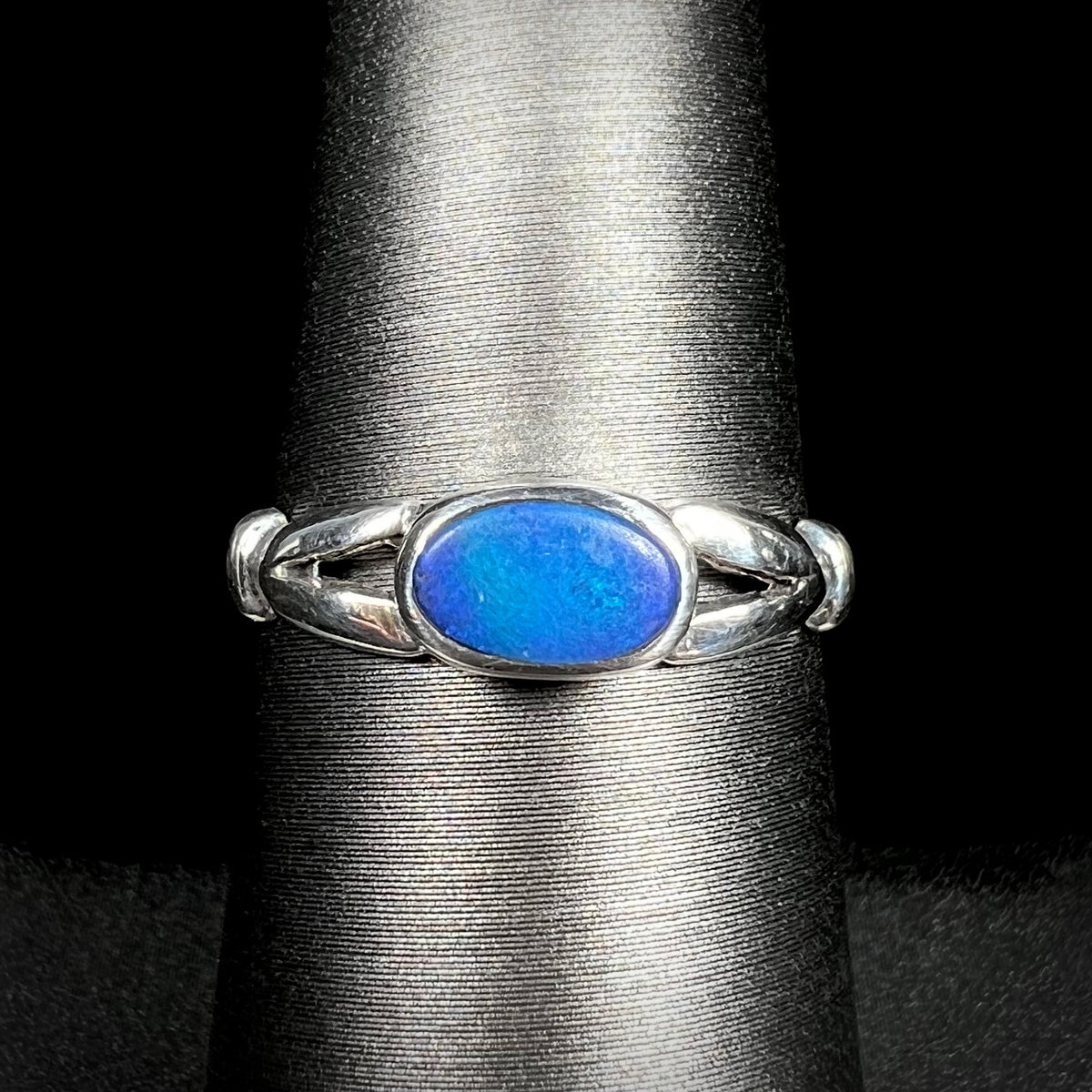 Close-up of refurbished estate women's sterling silver opal doublet ring on display
