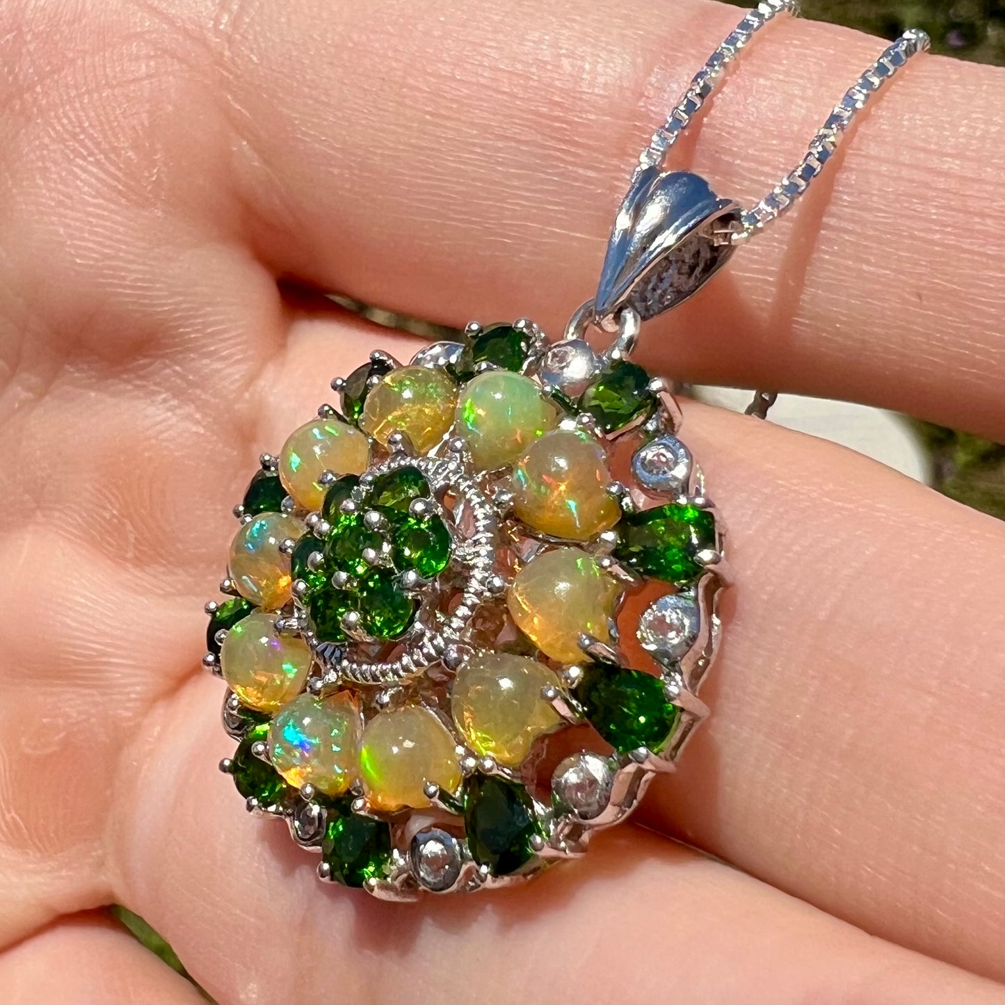 Angled close-up of an Ethiopian opal and chrome diopside necklace, shown in the sun.