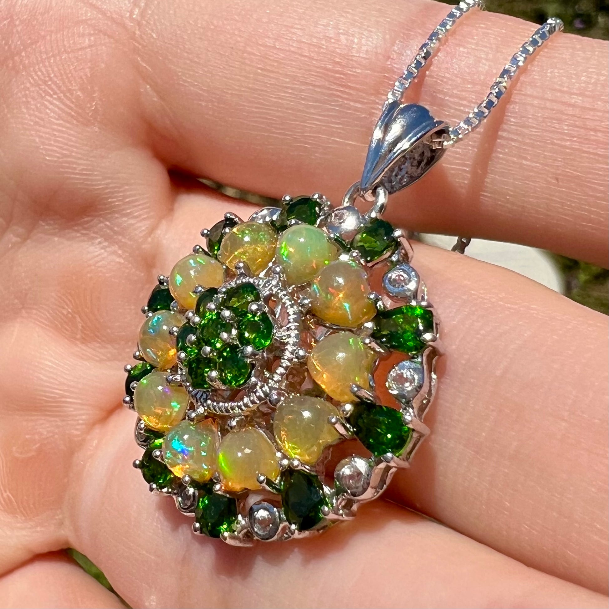 Angled close-up of an Ethiopian opal and chrome diopside necklace, shown in the sun.