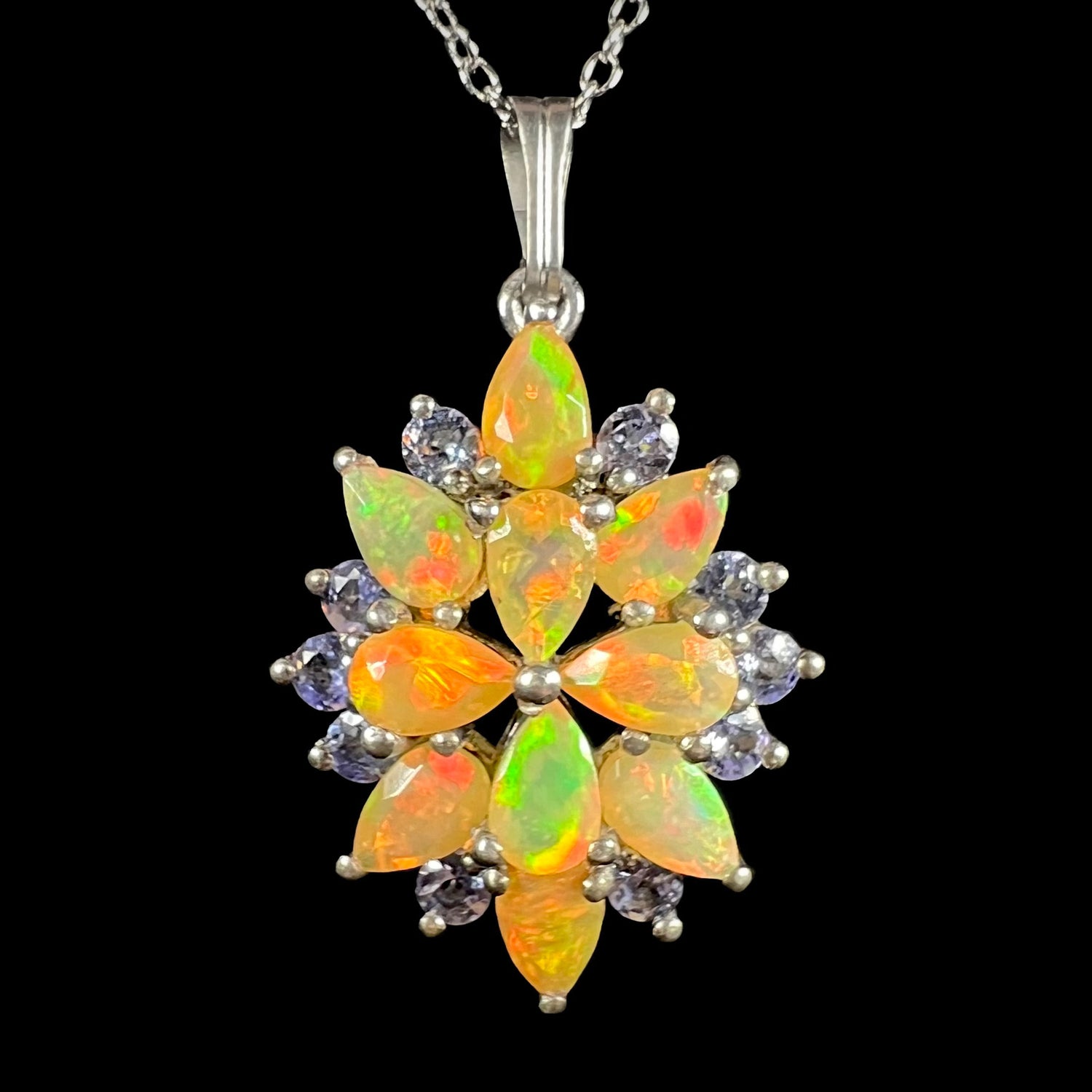 An Ethiopian opal cluster necklace with tanzanite accents made from sterling silver, shown from the front.