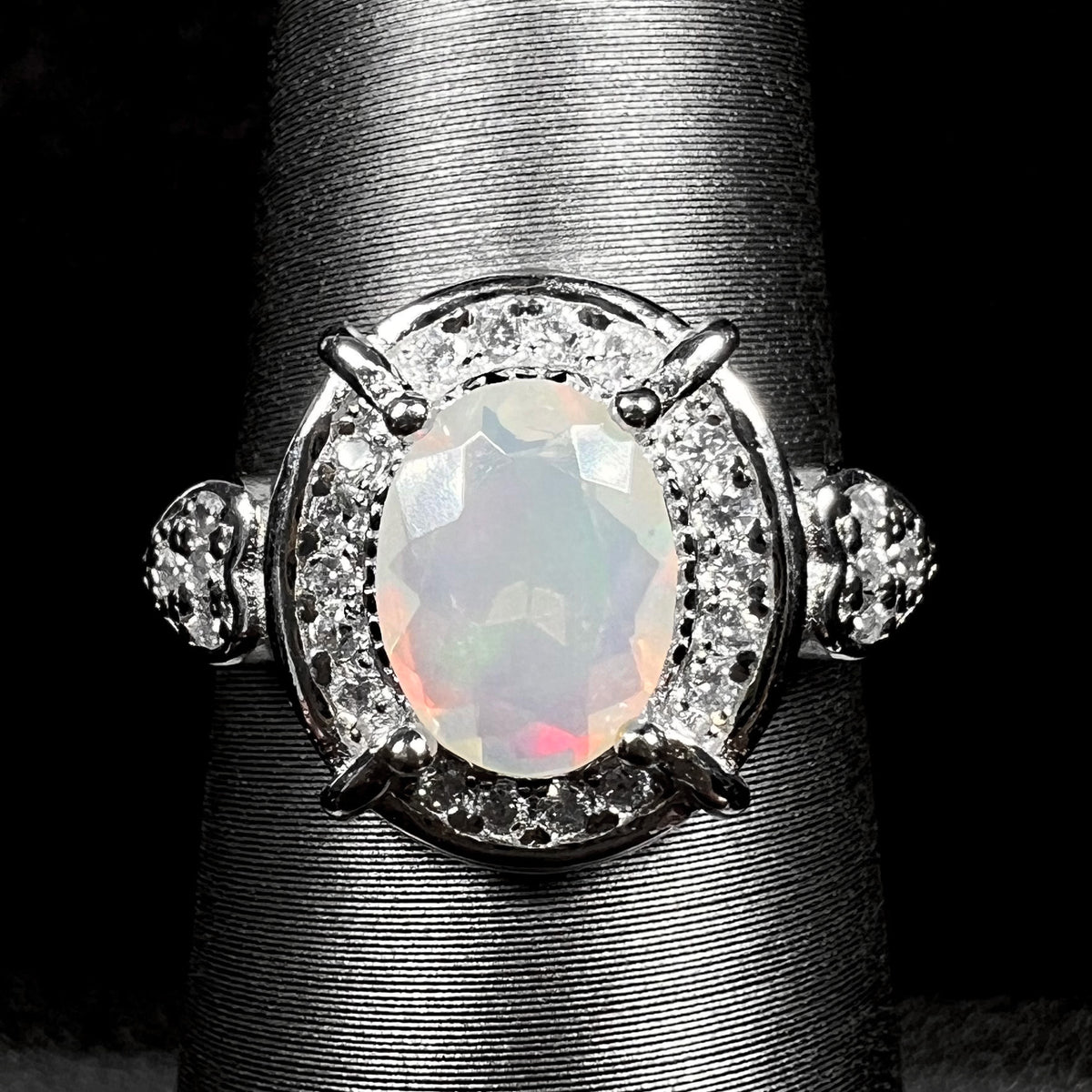 Close-up of women's sterling silver Ethiopian opal and CZ halo ring on display