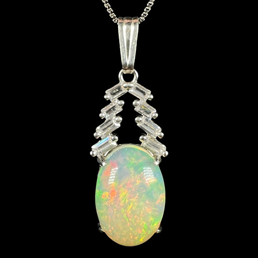 Close-up of women's sterling silver Ethiopian opal and emerald cut CZ drop pendant on chain