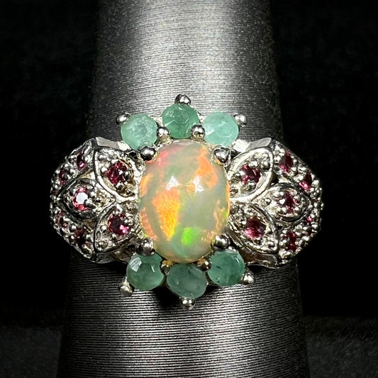 Close-up macro view of women's sterling silver Ethiopian opal, emerald, and garnet ring on display