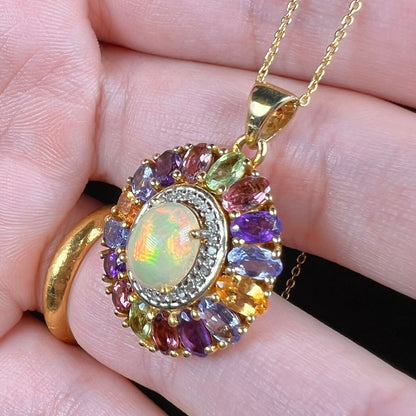 A gold plated sterling silver Ethiopian fire opal and multi-gemstone halo pendant shown from an angle.
