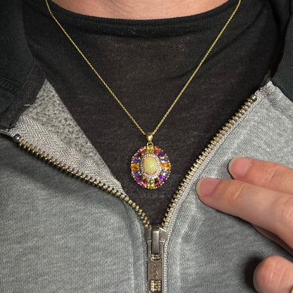 A gold plated sterling silver Ethiopian fire opal and multi-gemstone halo necklace worn around a neck.