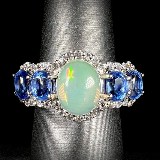 Front straight view of Ethiopian opal and blue kyanite ring, surrounded by a halo of white topaz.