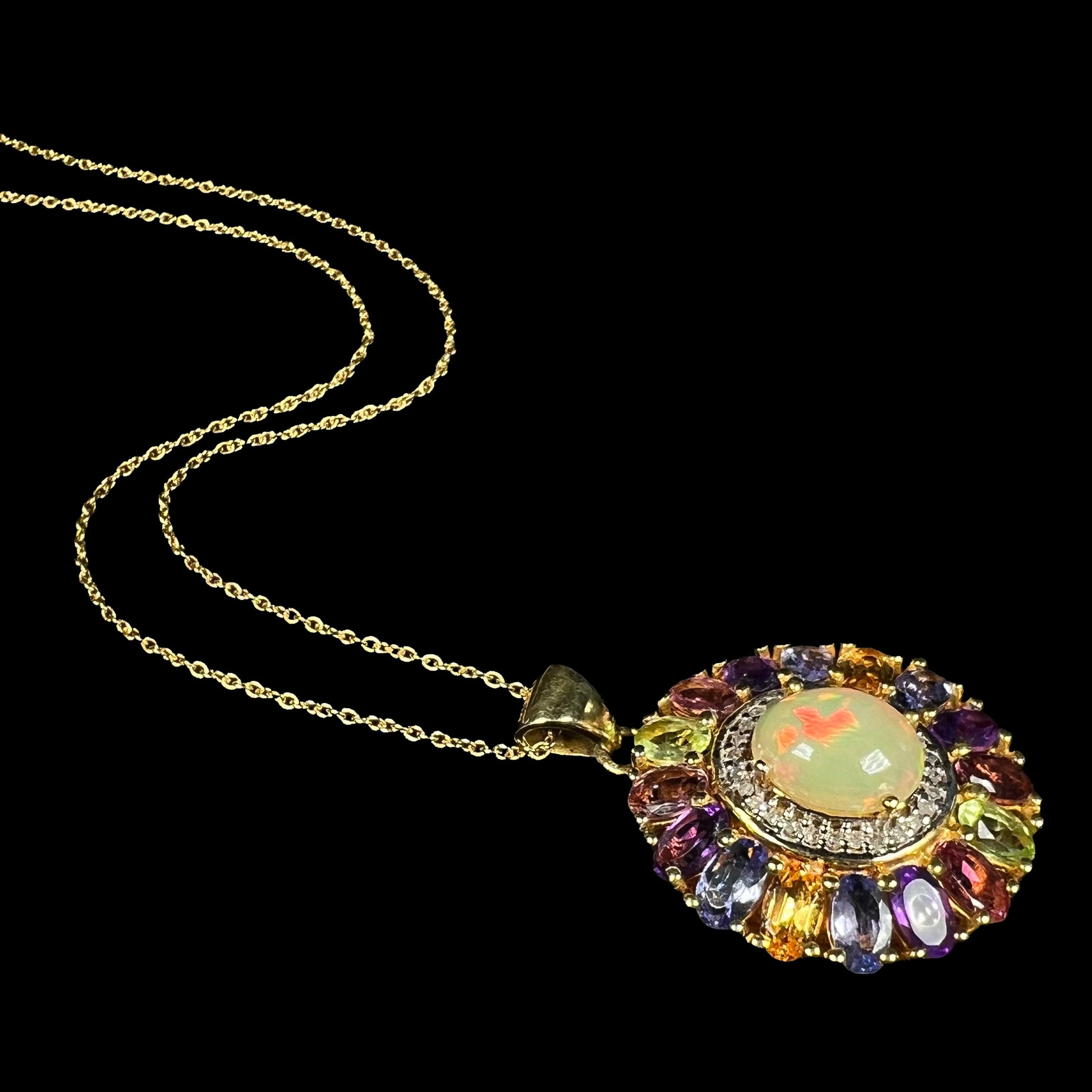 A gold plated sterling silver Ethiopian fire opal and multi-gemstone halo necklace shown from an angle.