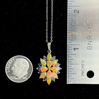 An Ethiopian opal cluster necklace that measures 1.25 inches long, resting next to a dime coin and ruler.
