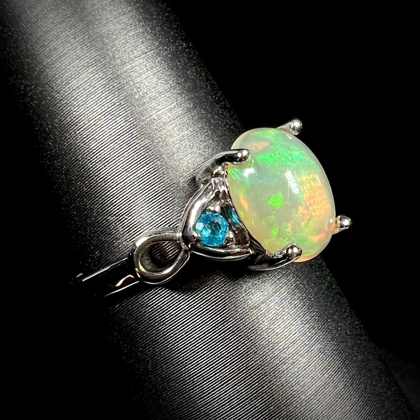 Ethiopian opal and blue apatite ring shown from angled view on ring display