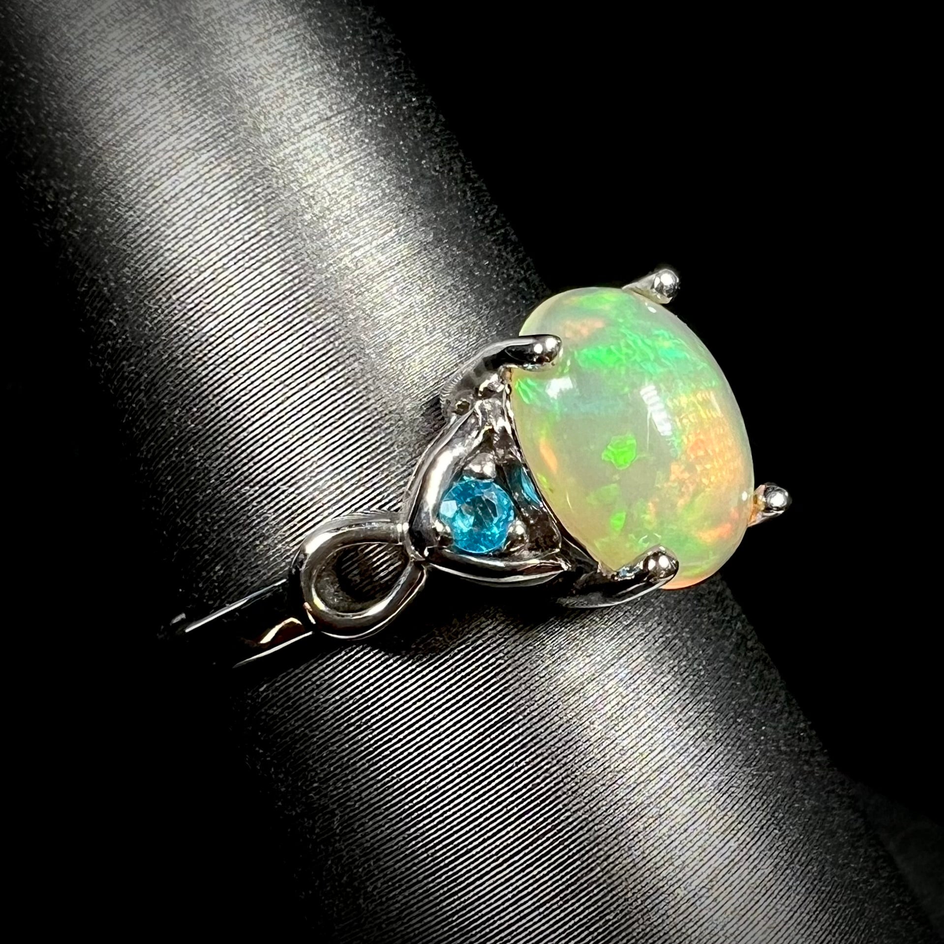 Ethiopian opal and blue apatite ring shown from angled view on ring display