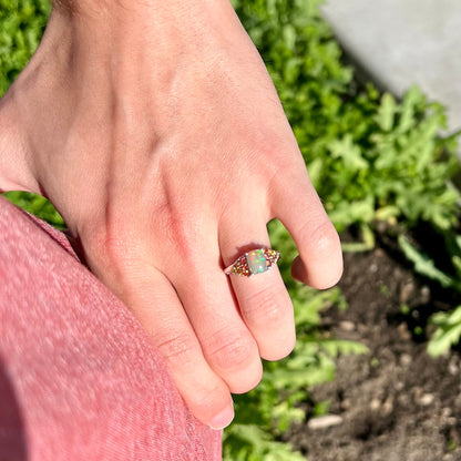 A ladies' silver ring set with a cushion cabochon cut Ethiopian fire opal stone and citrine accents.