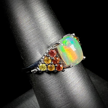 A ladies' silver ring set with a cushion cabochon cut Ethiopian fire opal stone and citrine accents.