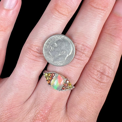 A ladies' silver ring set with a cushion cabochon cut Ethiopian fire opal stone and citrine accents.