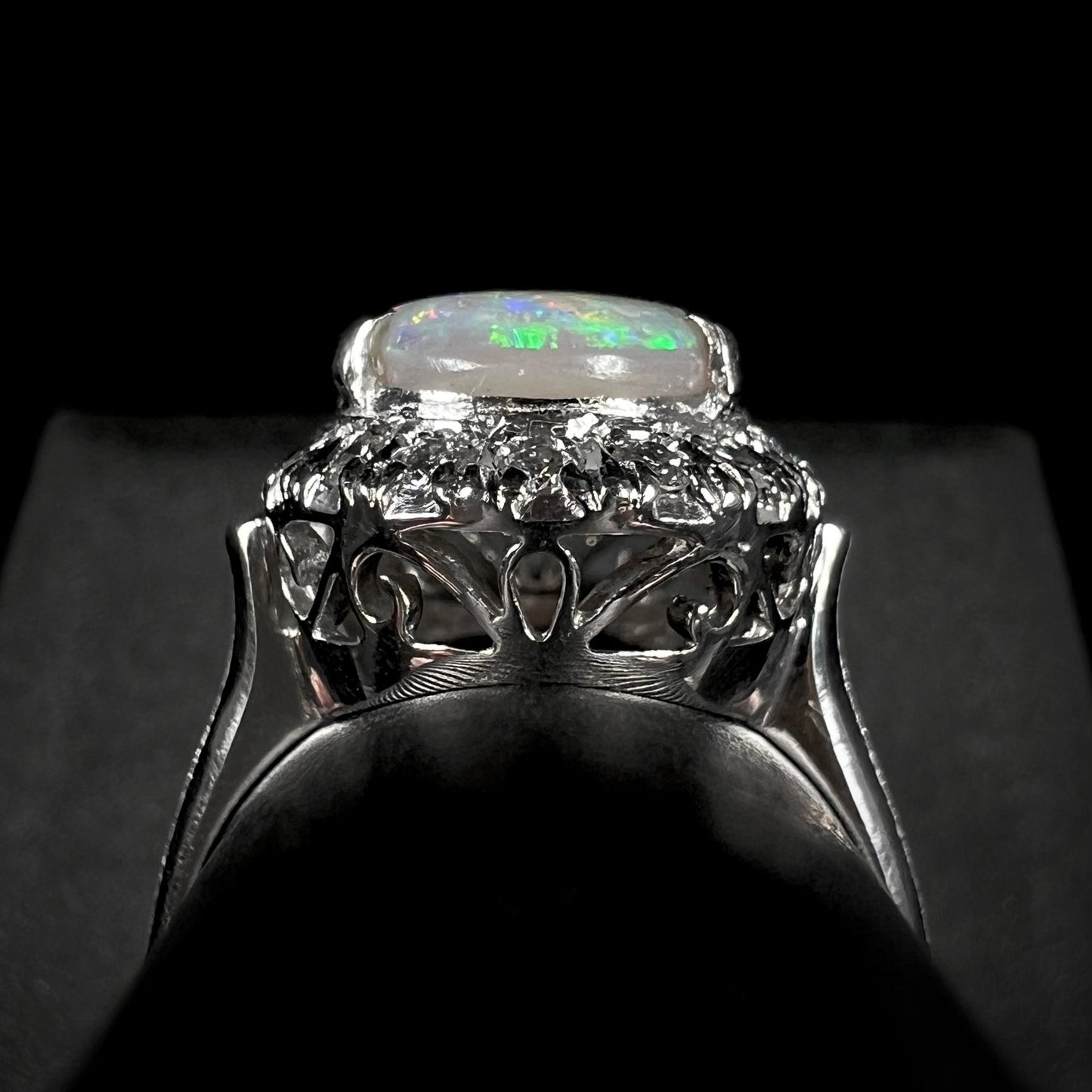 Filigree on the side of a platinum opal and diamond halo ring.