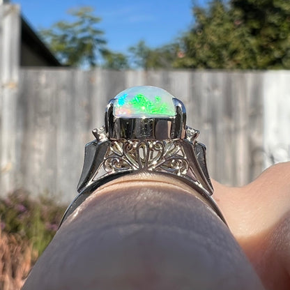 A platinum filigree ring set with a Lightning Ridge crystal opal and diamond accents.