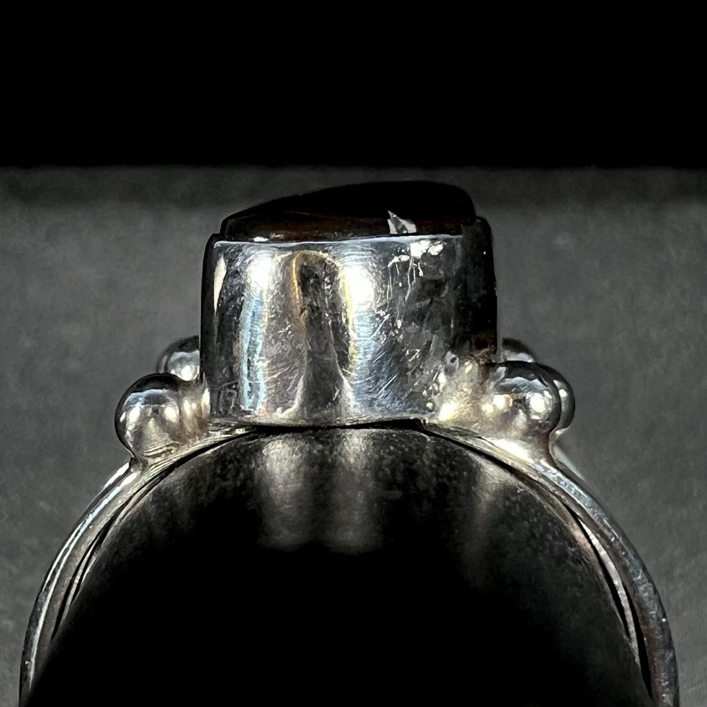 Gallery view of the handmade fire agate ring on a gray ring display.