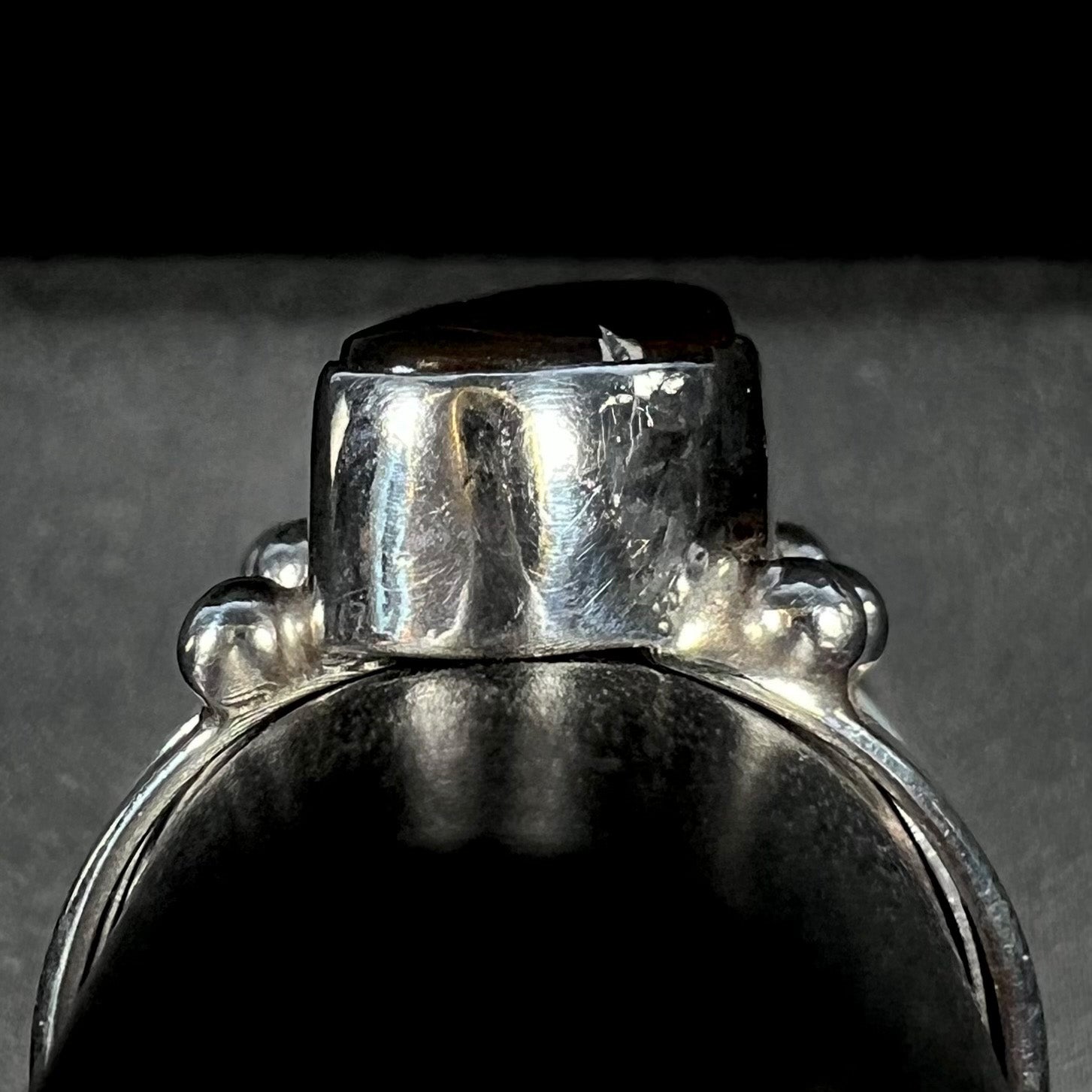 Gallery view of the handmade fire agate ring on a gray ring display.