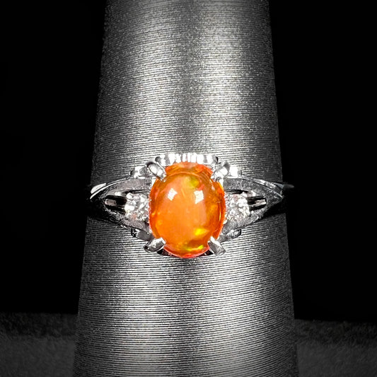 A Mexican fire opal platinum ring with delicate filigree details and diamond accents, perfect for an engagement or statement piece.