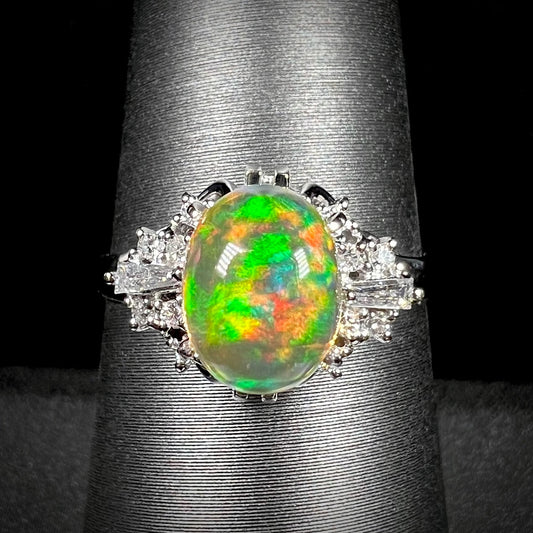 A platinum filigree ring mounted with a high-domed Mexican fire opal and baguette cut diamond accents.