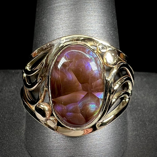 A men's yellow gold fire agate ring.  The fire agate is blue and purple with light scratches.