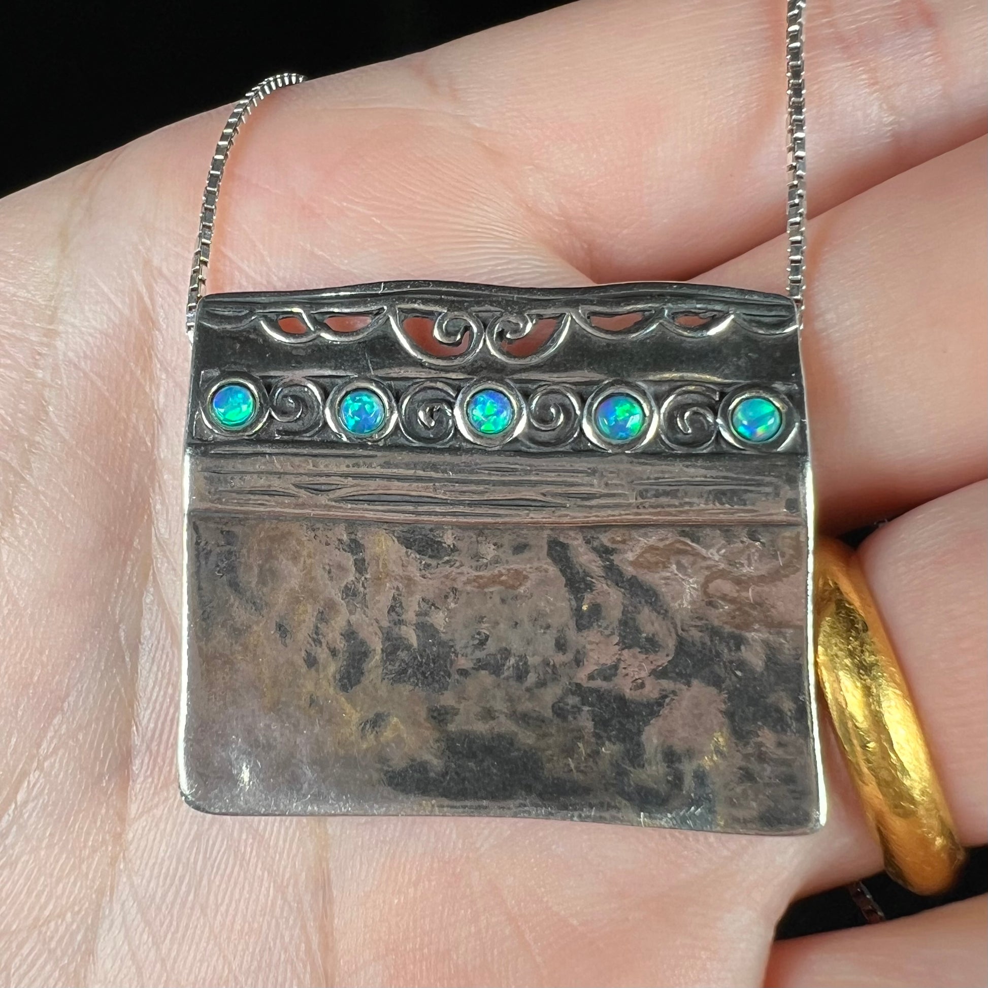 A handmade sterling silver five-stone opal necklace with a hammered finish by Israeli designer, Shablool Didae.