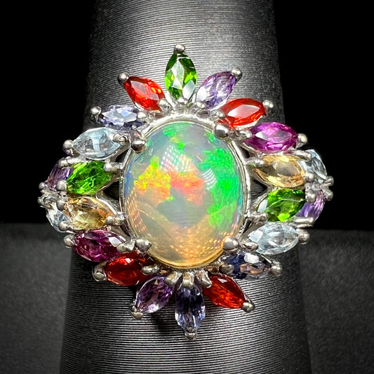 A flamboyant opal fruit salad ring set with multicolor gemstones in silver, shown from the front.