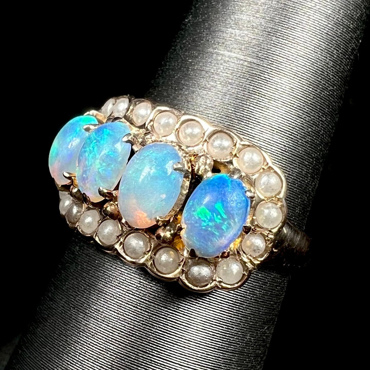 Four-stone Victorian crystal opal and seed pearl ring in yellow gold on ring display