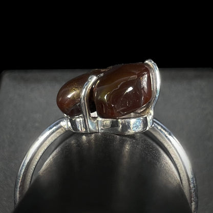 Macro gallery view of the fire agate ring against a black background, stone appears brown.
