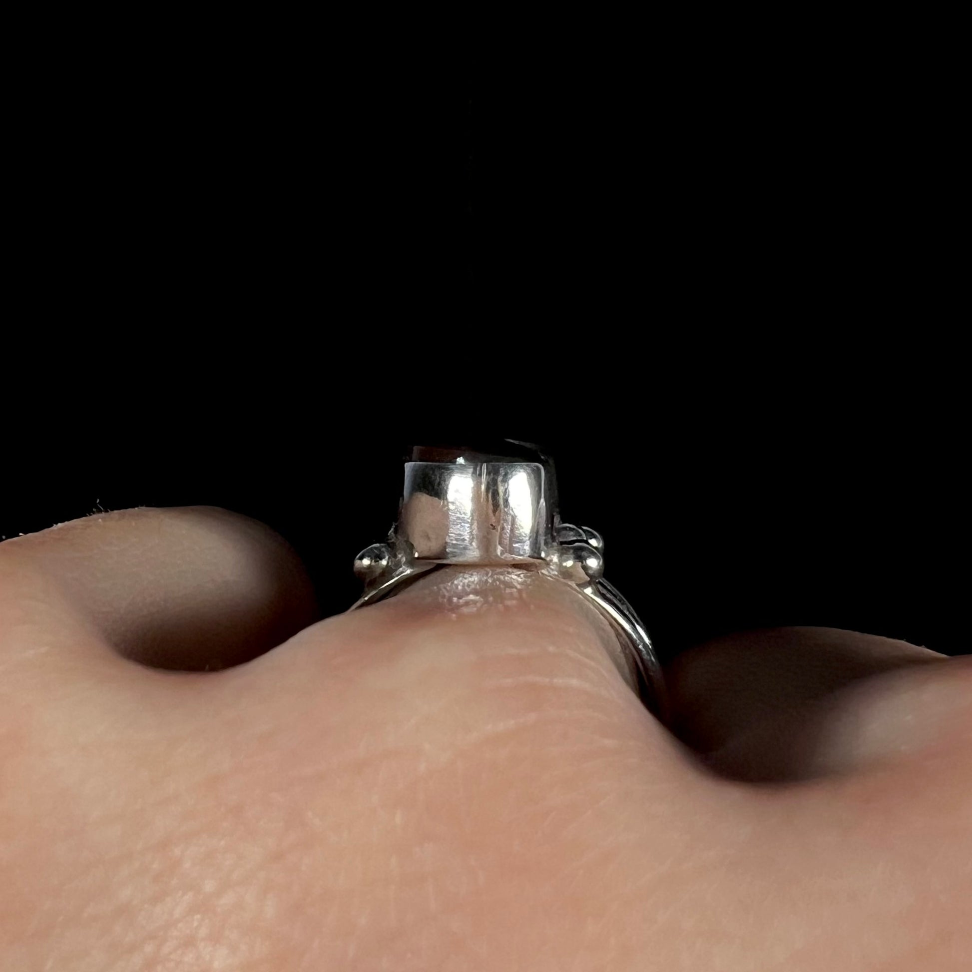 Macro gallery view of boho fire agate ring worn on hand.