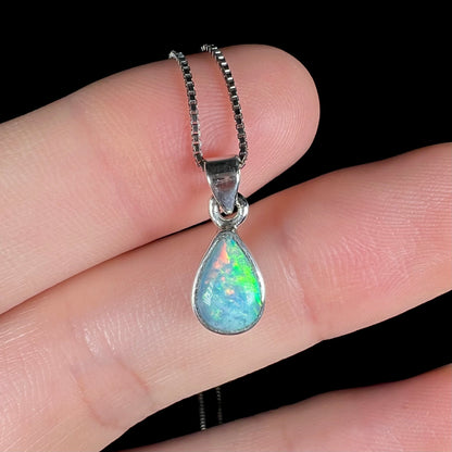 A dainty, sterling silver necklace bezel set with a natural, pear shaped opal stone.