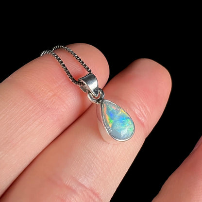 A dainty, sterling silver necklace bezel set with a natural, pear shaped opal stone.