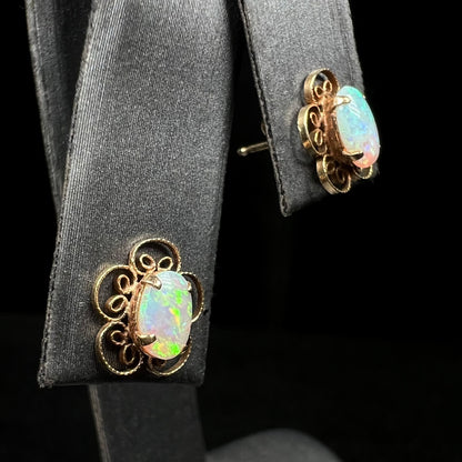 14k gold filigree flower design crystal opal stud earrings on earring display