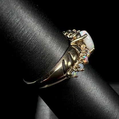 A yellow gold Australian opal crisscross ring, shown from the side view on a ring display.